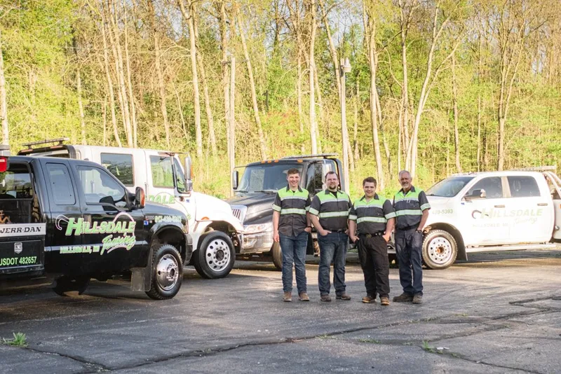 The Hillsdale Towing team standing with the company's fleet of trucks
