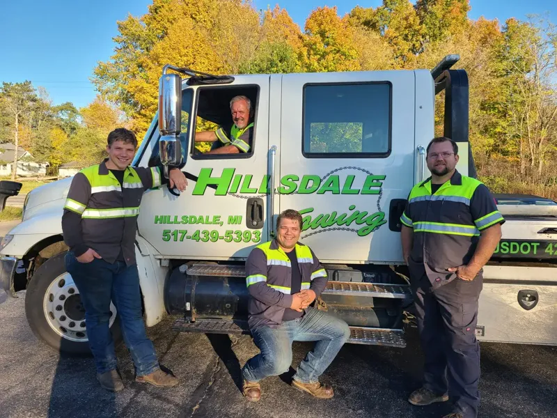 Hillsdale Towing employees posing around a heavy-duty tow truck