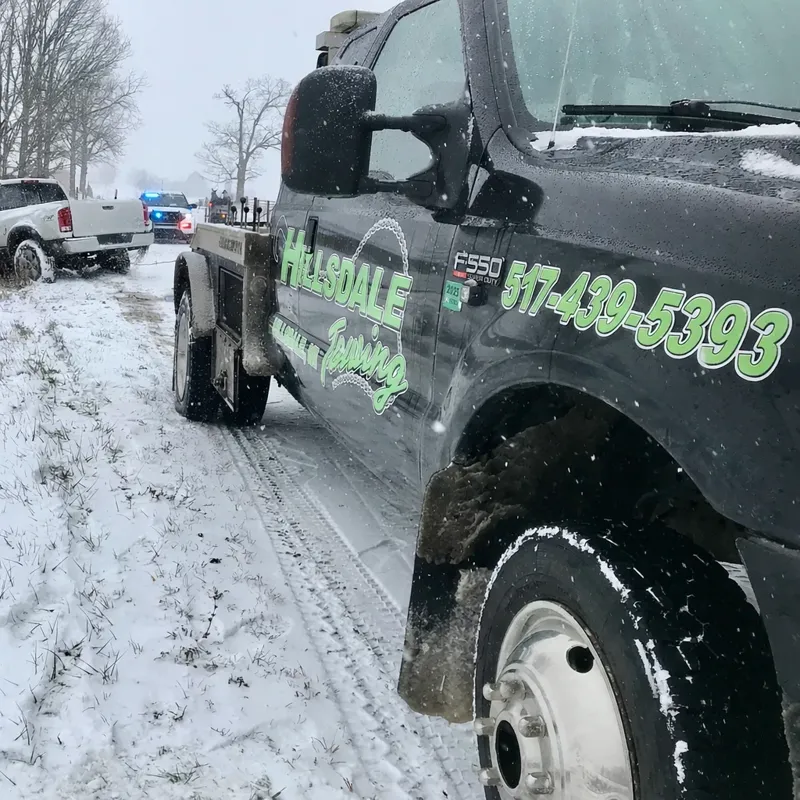 Hillsdale Towing truck assisting at a snowy roadside recovery